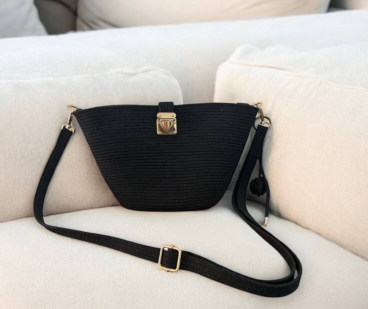 Bolso de cuerda negra con herrajes dorados y correa desmontable, estilo elegante